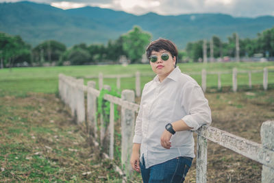 Portrait of fashionable young woman standing at farm