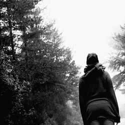 Woman standing on tree trunk