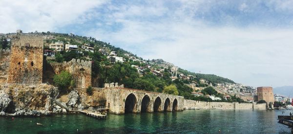 Arch bridge over river against sky
