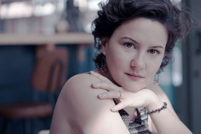 Close-up portrait of beautiful mature woman sitting indoors