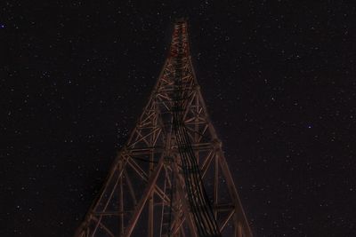 Low angle view of illuminated tower against sky at night