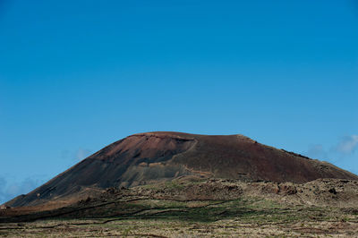 Scenic view of mountains against blue sky