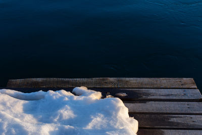 High angle view of pier over lake during winter with some snow pile on it