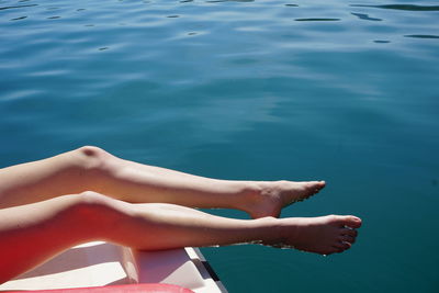 Low section of woman relaxing in swimming pool