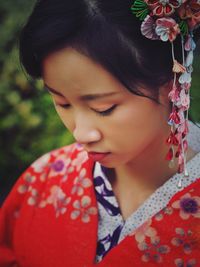 Close-up of beautiful young woman with red flowers