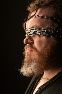 Portrait of man wearing hat against black background