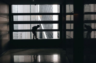 Silhouette boy standing by window