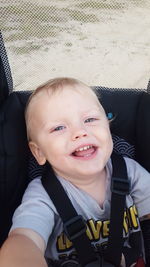 Close-up portrait of cute boy sitting at baby stroller