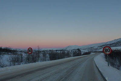 Road passing through snow covered landscape