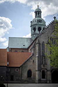 Low angle view of bell tower against cloudy sky