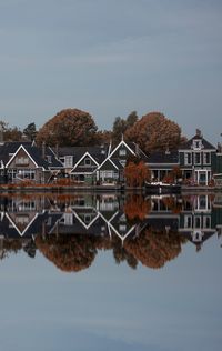 Reflection of house in water against clear sky