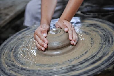 Cropped hands making pot