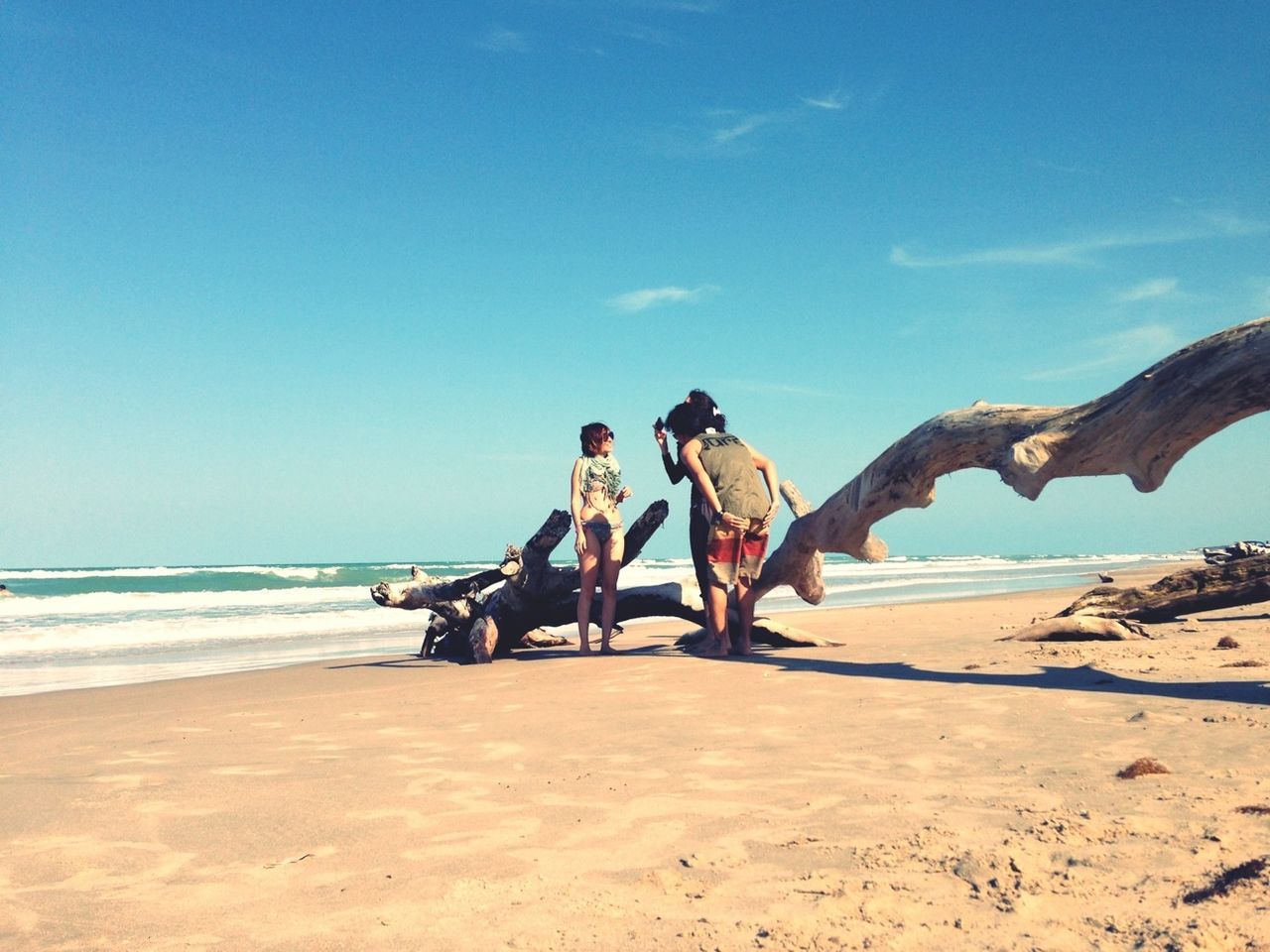 beach, lifestyles, sea, leisure activity, sand, togetherness, water, shore, men, bonding, vacations, full length, person, horizon over water, sky, friendship, enjoyment, love