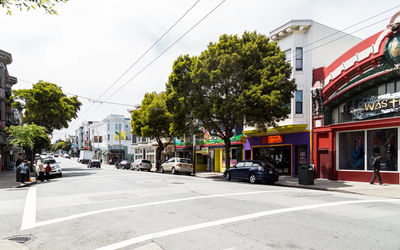 Cars on city street against sky