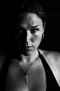 Close-up portrait of young woman wearing cross