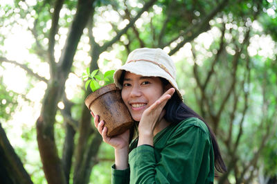 Portrait of woman wearing hat in forest