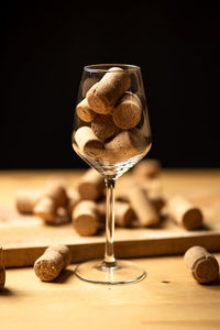 Close-up of wineglass on table against black background