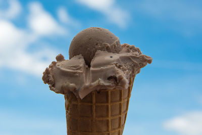 Close-up of ice cream cone against sky