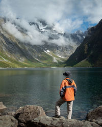 Rear view of man looking at mountains against sky