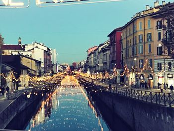 Canal amidst buildings against sky in city