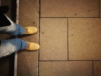 Low section of man standing on tiled floor