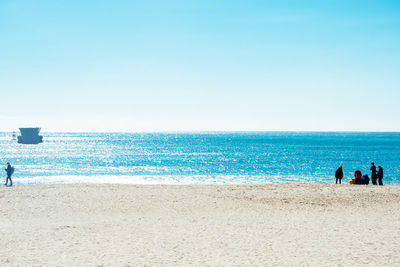 Scenic view of beach against clear blue sky