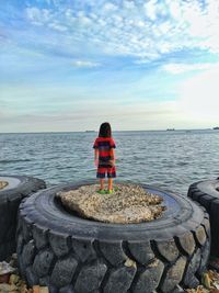 Rear view of woman looking at sea against sky