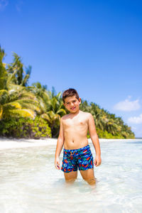 Shirtless man swimming in sea