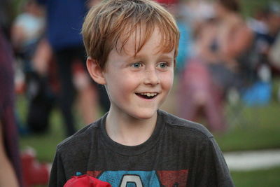 Close-up of cheerful boy looking away while standing at park