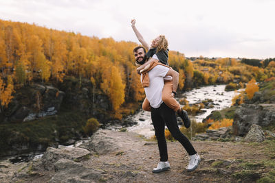 Happy people in love are travel hike in nature in the autumn forest. romantic trip to countryside