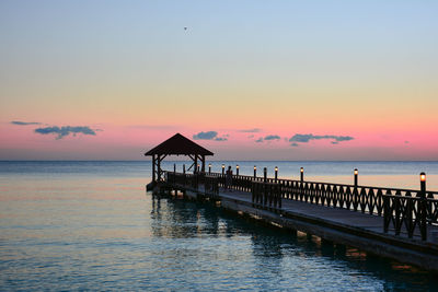 Pier on sea at sunset