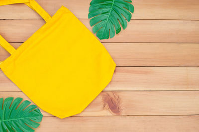 High angle view of yellow leaves on wooden table