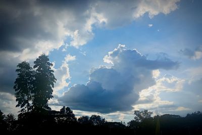 Low angle view of sunlight streaming through clouds