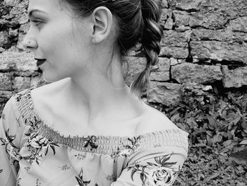 Portrait of woman looking away against wall