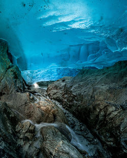Scenic view of frozen sea seen through cave