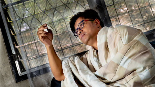 Young man looking through window