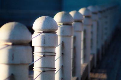 Close-up of metal railing against white wall