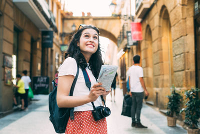 Young woman standing on street in city