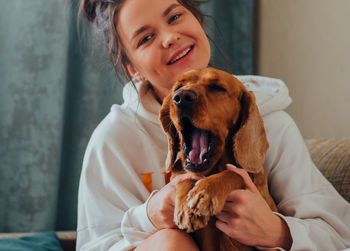 Portrait of woman with dog at home