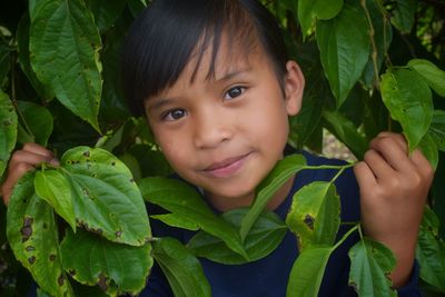 Portrait of cute boy smiling leaves outdoors