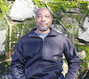 Portrait of young man standing against rock