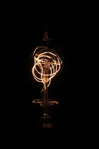 Low angle view of illuminated light bulb against sky at night