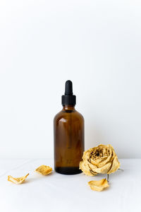 Close-up of glass bottle on table against white background