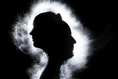 Close-up portrait of silhouette man over black background