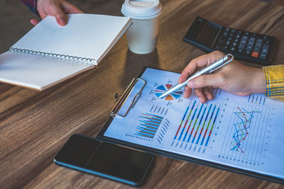 Cropped image of business colleagues analyzing paperwork on table