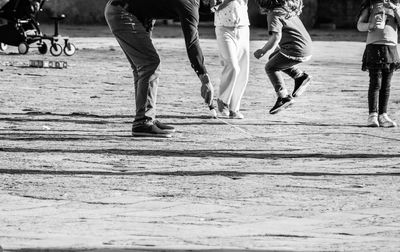 Low section of people playing with skipping rope