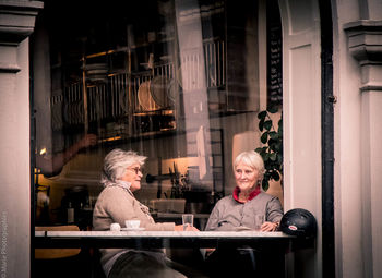 Happy friends sitting on table at cafe