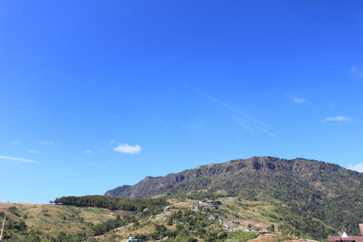 Scenic view of mountains against blue sky