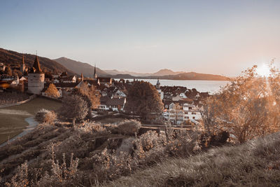 Scenic view of townscape by mountains against sky in zug