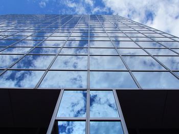Low angle view of modern building against cloudy sky